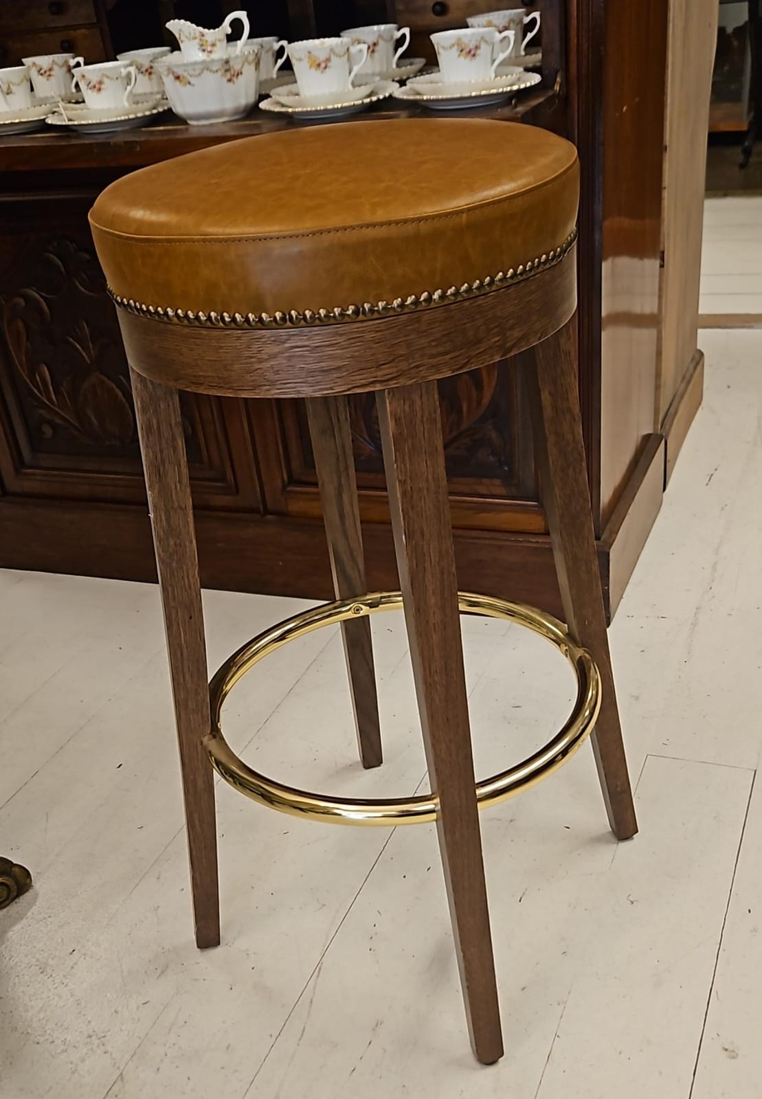 The main photo for Large Bar stool made from solid walnut with tan faux leather top and studden brass trim
